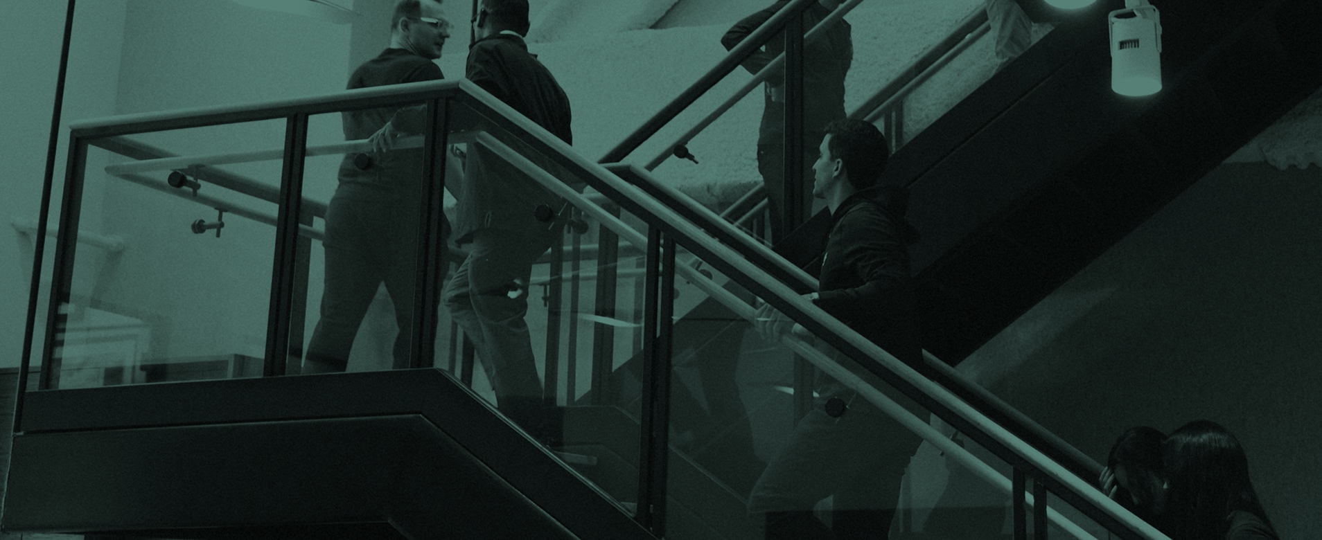 People walking up and down a staircase inside a modern office building.